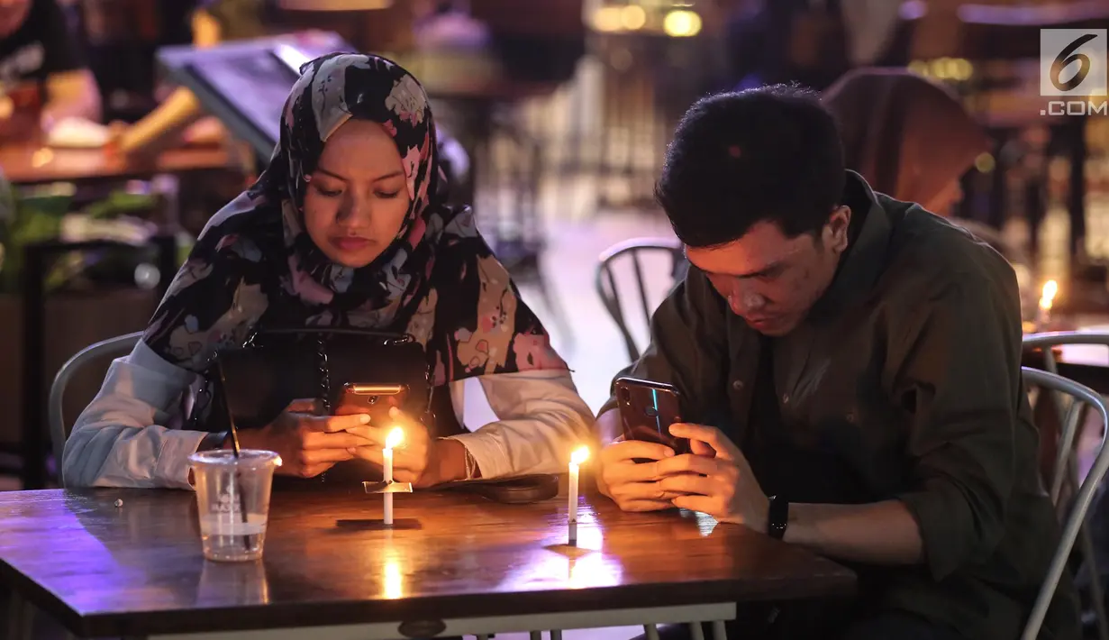 Pengunjung menyalakan lilin untuk mendukung Earth Hour 2019 di Lippo Mall Kemang, Jakarta, Sabtu (30/3). Lampu eksterior mall yang padam selama 60 menit merupakan wujud komitmen dan aksi terhadap dampak perubahan iklim serta pemanasan global. (Liputan6.com/Fery Pradolo)