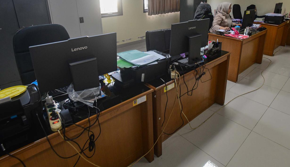 Kebijakan ini menjadi bagian dari strategi efisiensi energi di tengah dinamika global, termasuk konflik di Timur Tengah. Tampak dalam foto, pegawai bekerja di depan komputer dengan beberapa meja kursi yang kosong saat penerapan Work From Home (WFH) bagi Aparatur Sipil Negara (ASN) di kantor Kecamatan Limo, Depok, Jawa Barat, Jumat (10/4/2026). (merdeka.com/Arie Basuki)