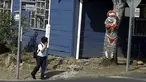 Seorang anak melihat pohon mangga yang dilukis oleh Gonzalo Sanchez di sudut jalan di lingkungan Escazu, Kosta Rika, Selasa (1/3). Lukisan bernama "The Woman in Red Bikini" itu menirukan sosok wanita yang mengenakan bikini. (REUTERS/Juan Carlos Ulate)