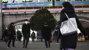 Orang-orang yang mengenakan masker untuk mengekang penyebaran virus corona COVID-19 berjalan di luar stasiun kereta di Tokyo, Jepang, Rabu (6/1/2021). Ibu kota Jepang itu mengkonfirmasi lebih dari 1.500 kasus baru virus corona COVID-19 pada 6 Januari 2021. (AP Photo/Eugene Hoshiko)