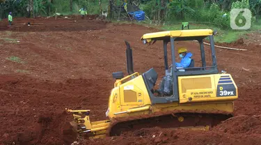 Petugas dengan alat berat meratakan tanah di belakang Blok AA-1 TPU Pondok Ranggon, Jakarta, Kamis (2/4/2020). Dinas Bina Marga Pemprov DKI melakukan pematangan atau perluasan lahan di TPU Pondok Ranggon untuk menangani permasalahan pemakaman korban corona Covid-19. (merdeka.com/Arie Basuki)