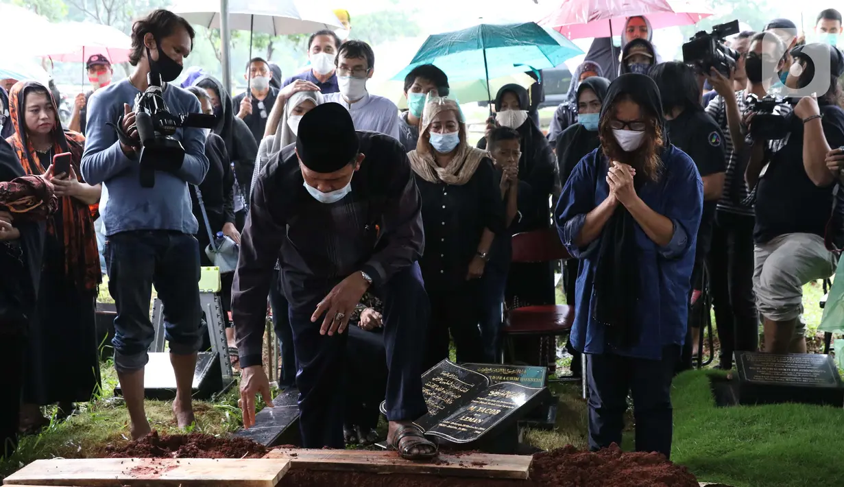 Istri mantan penggawa Timnas Indonesia Ricky Yacobi, Harly Ramayani (kanan) menyaksikan proses pemakaman suaminya di TPU Tanah Kusir, Jakarta, Sabtu (21/11/2020). Ricky Yacobi meninggal dunia pada Sabtu (21/11) akibat serangan jantung pada usia 57 tahun. (Liputan6.com/Helmi Fithriansyah)