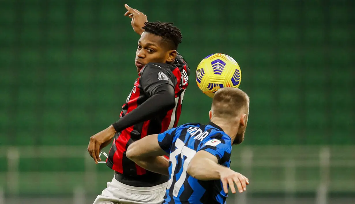 Striker AC Milan, Rafael Leao, duel udara dengan bek Inter Milan, Milan Skriniar, pada laga perempat final Coppa Italia di Giuseppe Meazza, Selasa (26/1/2021). Inter Milan menang dengan skor 2-1. (AP/Antonio Calanni)