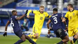 Penyerang Swedia, Dejan Kulusevski (center) berusaha melewati gelandang Prancis, Paul Pogba pada pertandingan UEFA Nations League di stadion Stade de France di Saint-Denis, Paris utara, Selasa (17/11/2020). Prancis menang atas Swedia 4-2. (AP Photo/Francois Mori)