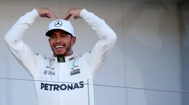 Pembalap F1 dari tim Mercedes Lewis Hamilton dari Inggris berpose di atas podium usai memenangkan GP F1 Jepang di Sirkuit Suzuka, Jepang, (8/10). Dengan kemenangan ini, Hamilton menjauh dari Sebastian Vettel di klasemen F1. (AP Photo / Toru Takahashi)