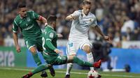 Pemain Real Madrid, Marcos Llorente (kanan) mengecoh dua pemain Leganes pada perempat final Copa del Rey di Santiago Bernabeu stadium, Madrid, (24/1/2018). Leganes menang 2-1. (AP/Francisco Seco)