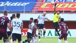 Kiper PSM Makassar, Hilman Syah (kanan) mencoba menghalau bola dari ancaman pemain Persikabo 1973, Veniamin Shumeyko dalam laga pekan ke-9 BRI Liga 1 2021/2022 di Stadion Maguwoharjo, Sleman, Selasa (26/10/2021). (Bola.com/Nandang Permana)