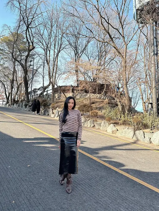 Lyodra mengenakan lengan panjang monogram cokelat dengan rok midi lateks yang trendy [@lyodraofficial]