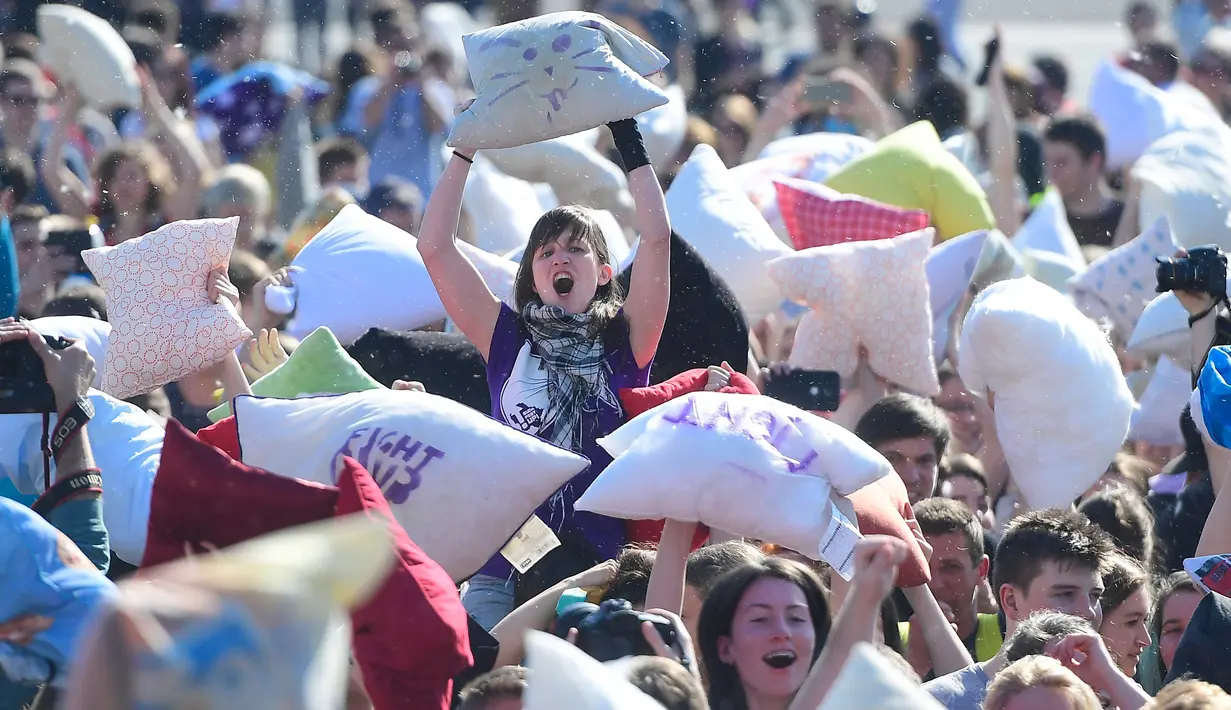 Seorang wanita mengangkat bantalnya saat mengikuti perang bantal dalam Hari Perang Bantal Sedunia (International Pillow Fight Day) 2017 di Budapest, Hongaria (1/4). (Tamas Kovacs / MTI via AP)
