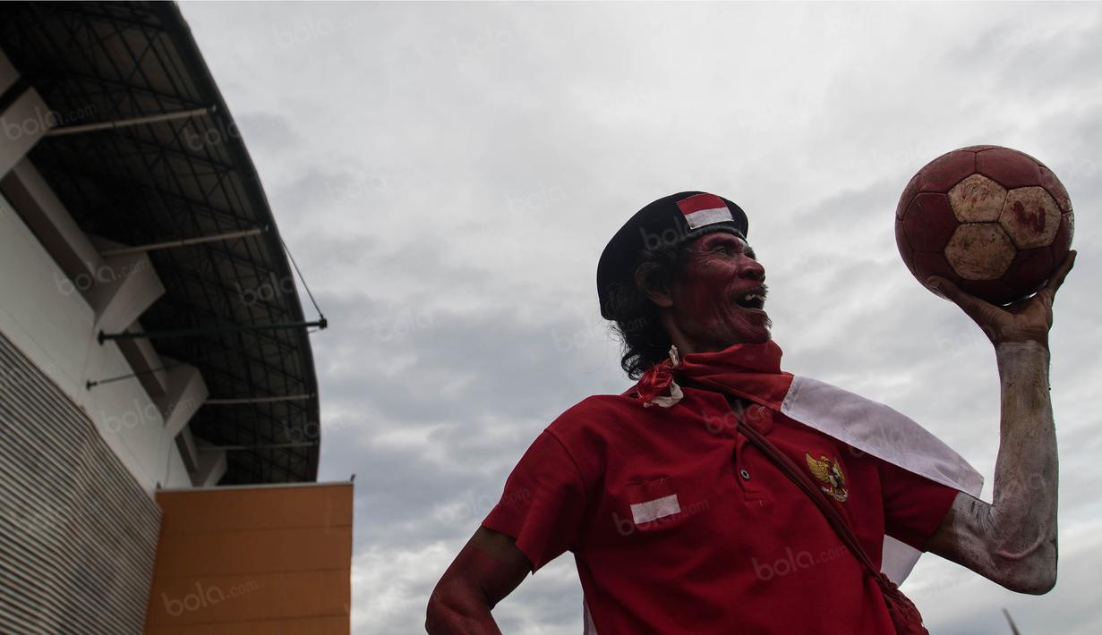 Seorang suporter yang mewarnai tubuhnya merah putih berpose sebelum menonton Timnas Indonesia yang akan bertanding melawan Vietnam di Stadion Pakansari, Jawa Barat, Sabtu (3/12/2016). (Bola.com/Vitalis Yogi Trisna)