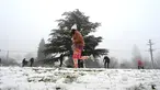 Orang-orang menikmati hujan salju pertama musim ini di Katoomba di pegunungan Blue Mountains, Kamis (10/6/2021). Katoomba berada di New South Wales, selatan Australia atau 102 kilometer sebelah barat Sydney.  (AFP/Saeed KHAN)