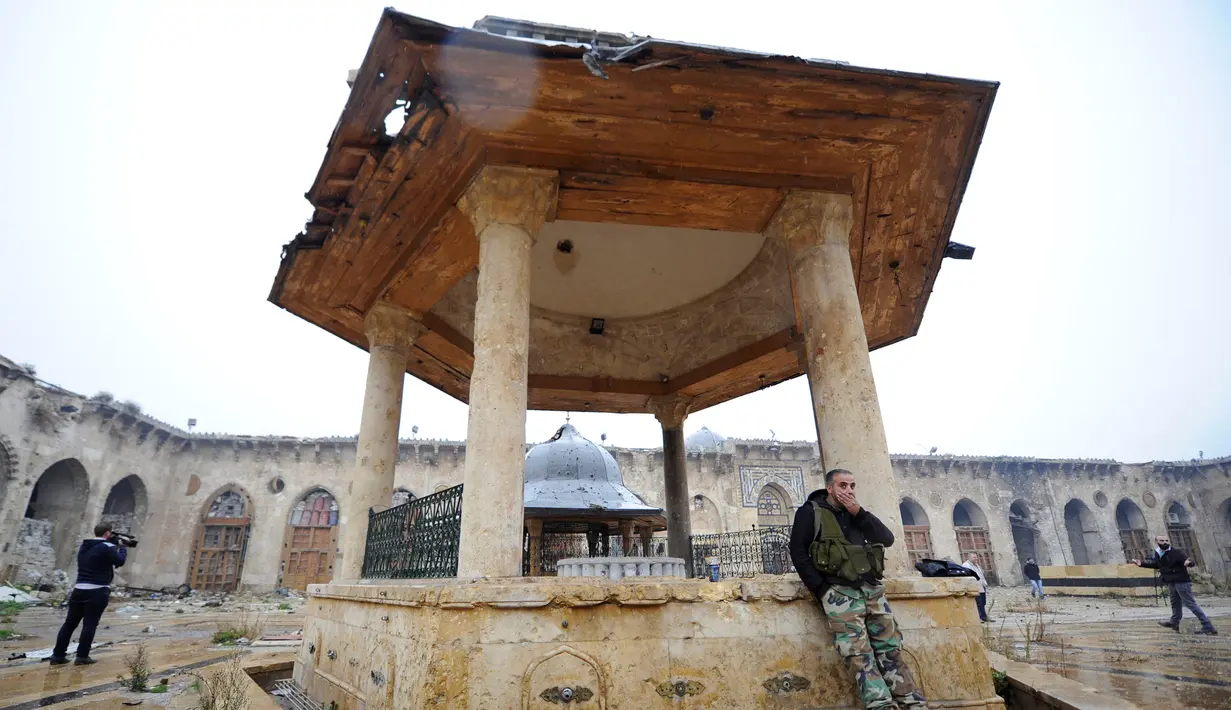 Seorang anggota pasukan Presiden Suriah Bashar al-Assad berdiri di salah satu bangunan yang berada di kompleks Masjid Umayyad, Aleppo di Suriah, 13 Desember 2016. Masjid ini menjadi salah satu masjid tertua di dunia. (REUTERS/Omar Sanadiki)