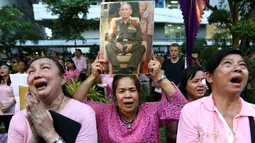 Warga membawa gambar Raja Thailand Bhumibol Adulyadej di RS Siriraj, Bangkok, Thailand, Kamis (13/10). Hingga akhir hayatnya, Raja Bhumibol Adulyadej merupakan raja yang paling lama berkuasa di dunia. (REUTERS / Chaiwat Subprasom)