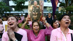 Warga membawa gambar Raja Thailand Bhumibol Adulyadej di RS Siriraj, Bangkok, Thailand, Kamis (13/10). Hingga akhir hayatnya, Raja Bhumibol Adulyadej merupakan raja yang paling lama berkuasa di dunia. (REUTERS / Chaiwat Subprasom)