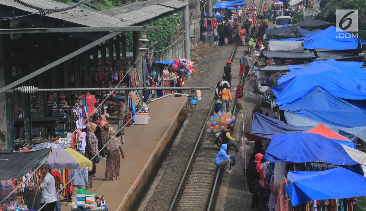 Warga Gunung Putri melakukan aktivitas jual beli di pasar dadakan yang berada di sisi rel KRL Nambo, Citeureup, Bogor (20/4). Meskipun berbahaya para pedagang tetap menjajakan dagangannya di tempat tersebut. (Merdeka.com/Arie Basuki)
