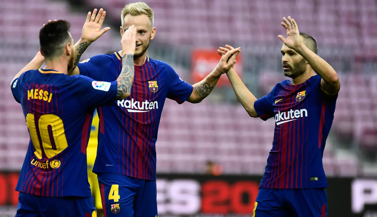 Pemain Barcelona, Lionel Messi bersama Ivan Rakitic dan Andres Iniesta merayakan gol ke gawang Las Palmas pada pertandingan Liga Spanyol di Camp Nou, Senin (2/10) dini hari. Bermain tanpa suporter, Barcelona menang telak dengan skor 3-0. (JOSE JORDAN/AFP)