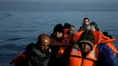 Pengungsi dan imigran saat berada di kapal di sampan kecil usai melintasi pulau Lesbos, Yunani, Senin (9/11). Sejak tahun 2015 lebih dari 590.000 imigran menyeberang ke Yunani akibat perang yang terjadi di Suriah. (REUTERS/Alkis Konstantinidis)