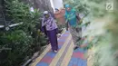 Warga melintas di salah satu gang kampung hijau di kawasan Malakasari, Jakarta, Sabtu (15/9). Tingginya kesadaran masyarakat akan pentingnya tumbuhan membuat kawasan tersebut terlihat asri dan dipenuhi berbagai tanaman. (Liputan6.com/Immanuel Antonius)