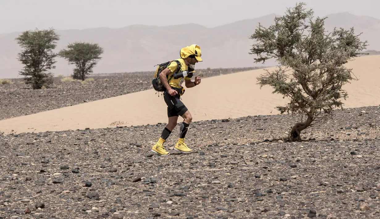 Seorang peserta ambil bagian dalam kejuaraan Marathon des Sables ke-33 tahap kedua di Gurun Sahara, selatan Maroko, Senin (9/4). Marathon yang diselenggarakan sejak 1986 ini tiap tahun diadakan di Gurun Sahara pada bulan April. (JEAN-PHILIPPE KSIAZEK/AFP)