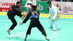 Pesilat Indonesia, Komang Harik Adiputra melepas tendangan ke arah pesilat Timor Leste, David No-Ano Ximenes pada kelas 65-70 kg Putra Asian Games 2018 di Padepokan Pencak Silat TMII, Jakarta, Kamis (23/8). Komang unggul 5-0. (Liputan6.com/Fery Pradolo)