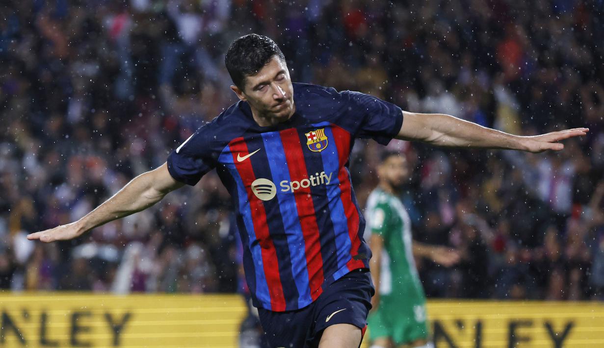 Pemain Barcelona, Robert Lewandowski, melakukan selebrasi setelah mencetak gol ke gawang Real Betis pada laga Liga Spanyol di Stadion Camp Nou, Minggu (30/4/2023). Barca menang telak 4-0 atas Betis. (AP Photo/Joan Monfort)