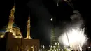 Kembang api dinyalakan di dekat pohon Natal yang dirancang oleh desainer Lebanon, Elie Saab di depan Masjid Al-Amin, di pusat kota Beirut, 12 Desember 2015. (REUTERS/Jamal Saidi)