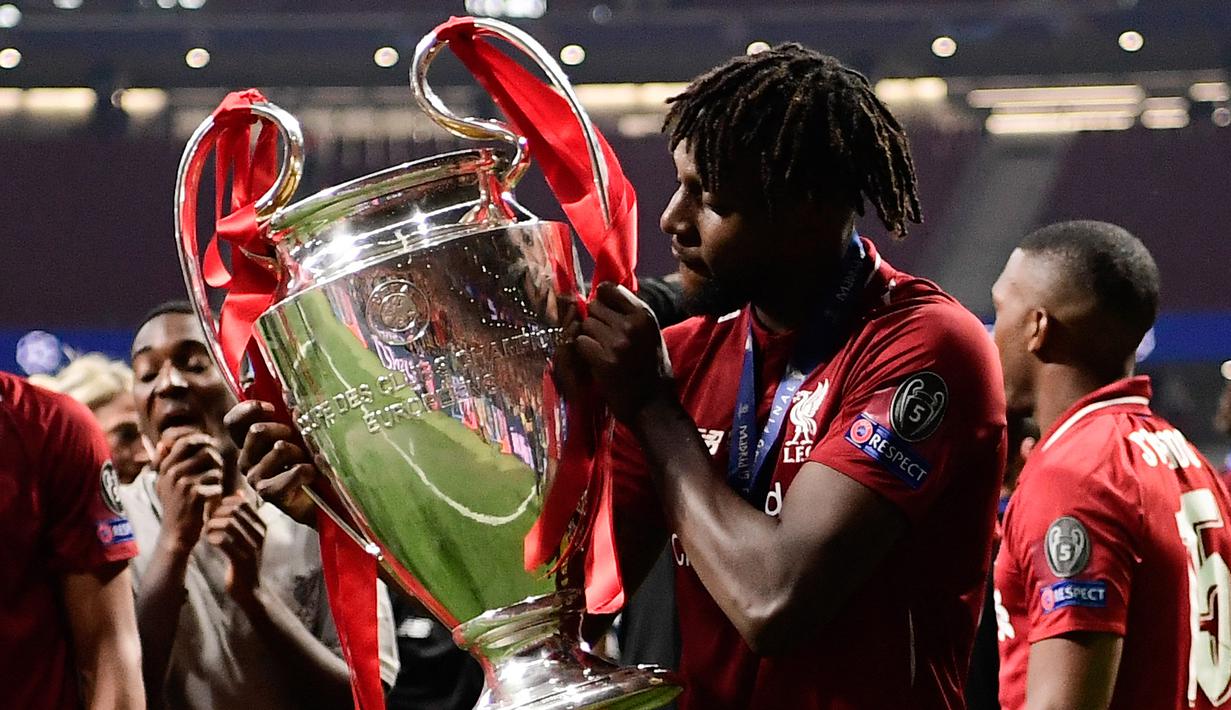 Selebrasi striker Liverpool, Divock Origi dengan trofi Liga Champions 2018/2019 dalam perayaan gelar juara setelah mengalahkan Tottenham Hotspur pada laga final di Wanda Metropolitano Stadium, Madrid (1/6/2019). Divock Origi mampu meraih trofi Liga Champions bersama Liverpool pada musim 2018/2019. Ia total tampil dalam 8 laga di Liga Champions musim 2018/2019 dengan mencetak 3 gol. Dua gol dicetaknya di leg kedua semifinal saat menang 4-0 atas Barcelona dan satu gol pada laga final saat menang 2-0 atas Tottenham Hotspur. (AFP/Javier Soriano)