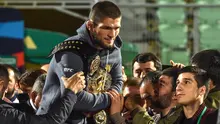 Juara kelas ringan UFC, Khabib Nurmagomedov membawa sabuk juaranya saat disambut oleh para penggemar setibanya di Makhachkala, Rusia, Senin (8/10). Nama Khabib menjadi terkenal setelah dirinya berhasil mengalahkan Conor McGregor. (AFP/Vasily MAXIMOV)