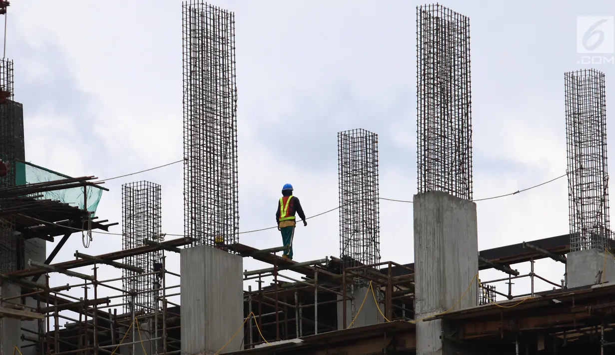 Seorang pekerja berjalan di atas bangunan gedung yang dalam tahap penyelesaian di Jakarta, Jumat (26/1). Jumlah tenaga kerja konstruksi yang tersertifikasi saat ini di bawah 10% atau hanya 720.000 dari 8,10 juta tenaga kerja. (Liputan6.com/Angga Yuniar)