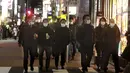 Orang-orang memakai masker untuk melindungi dari penyebaran virus corona berjalan di sepanjang jalan yang dipenuhi bar dan restoran di Tokyo, Rabu (19/1/2022). Para pemimpin lokal mempersingkat jam buka restoran, karena kasus omicron mencapai rekor tertinggi di ibu kota. (AP Photo/Koji Sasahara)
