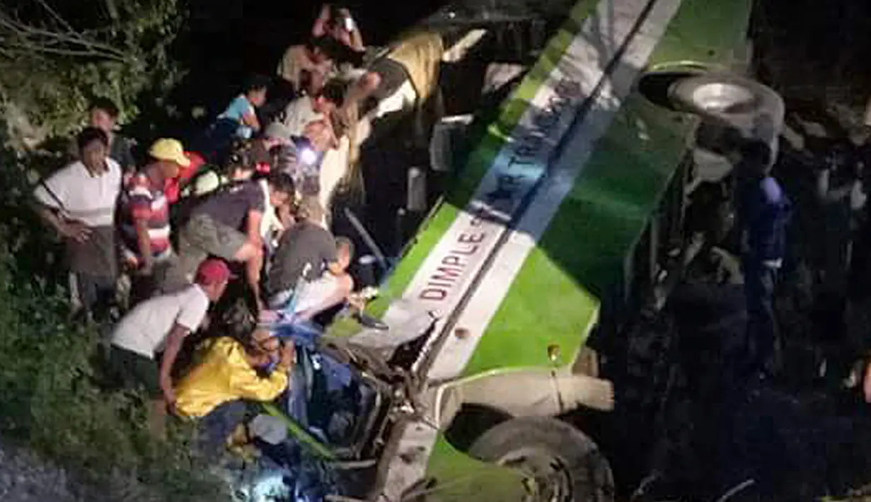 Tim penyelamat dan sukrelawan mengevakuasi korban kecelakaan bus di dekat Kota Sablayan, Mindanao, Filipina, Selasa (20/3). Bus sarat penumpang itu miring lalu menabrak pagar pembatas sebelum kemudian jatuh ke jurang. (PDRRMO, Mindoro Occidental via AP)