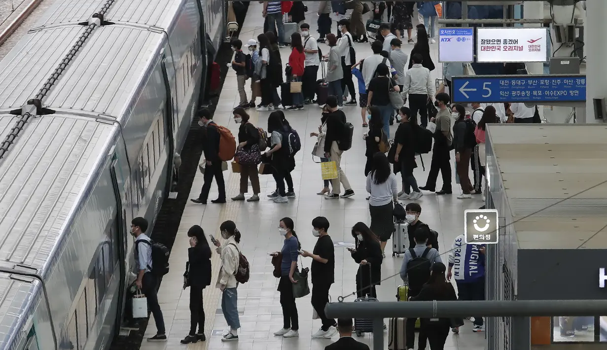 Penumpang memakai masker untuk membantu melindungi dari penyebaran virus corona berbaris untuk naik kereta menjelang liburan Chuseok atau Hari Thanksgiving versi Korea di Stasiun Kereta Seoul di Seoul, Korea Selatan, Selasa (29/9/2020). (AP Photo / Ahn Young-joon)