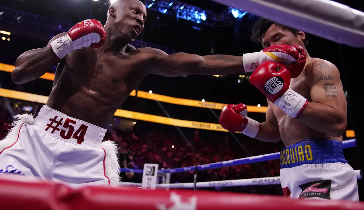 Yordenis Ugas dari Kuba saat memukul Manny Pacquiao, dari Filipina, dalam duel perebutan sabuk juara WBA super kelas welter di Las Vegas, Minggu (22/8/2021). Ugas menang angka atas Pacquiao 115-113, 116-112, dan 116-112. (AP Photo/John Locher)