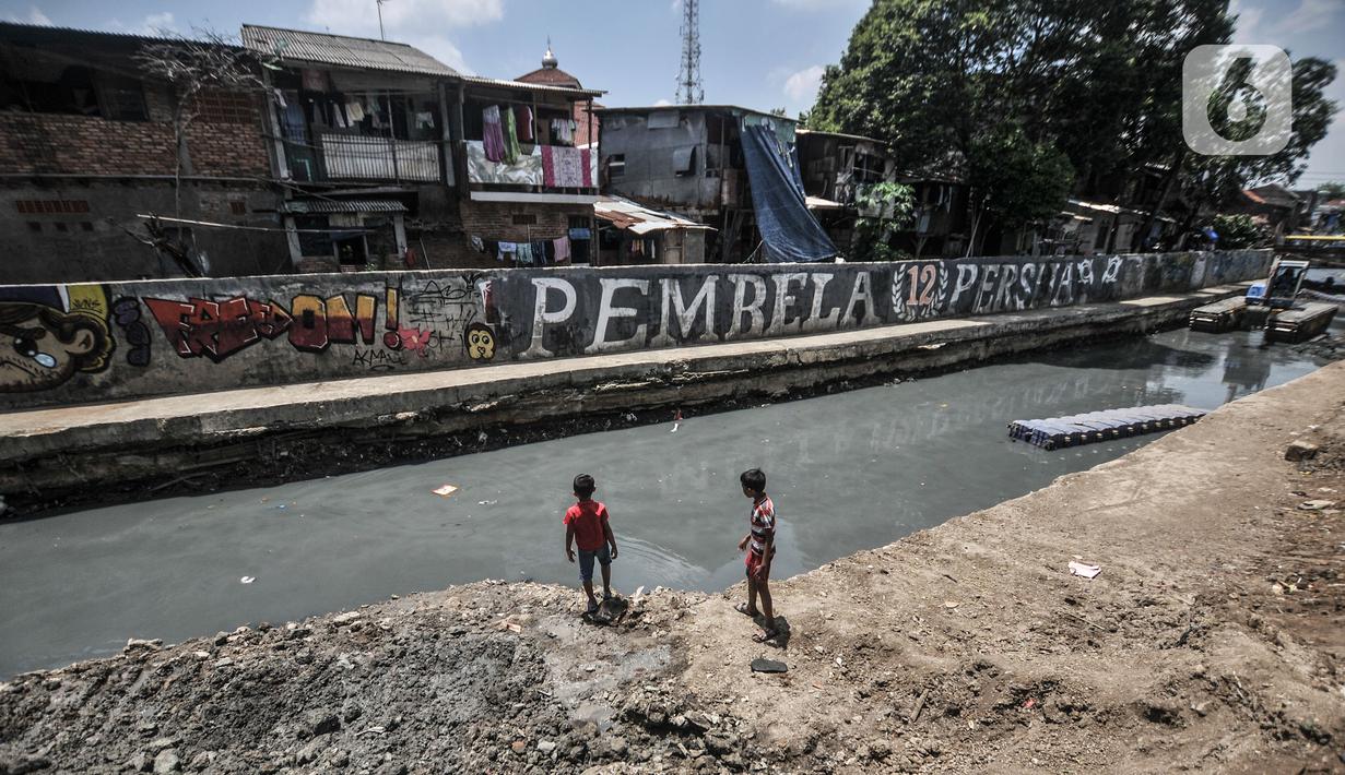 Anak-anak bermain di sekitar Kali Sentiong, Kecamatan Johar Baru, Rabu (22/9/2021). Pengerukan lumpur Kali Sentiong sekaligus mencegah banjir di kawasan tersebut yang kerap terjadi saat musim hujan. (merdeka.com/Iqbal S. Nugroho)