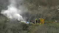 Petugas kebakaran sedang memadamkan api yang berada di helikopter yang menyebabkan Kobe Bryand tewas. (AP Photo/Mark J. Terrill)