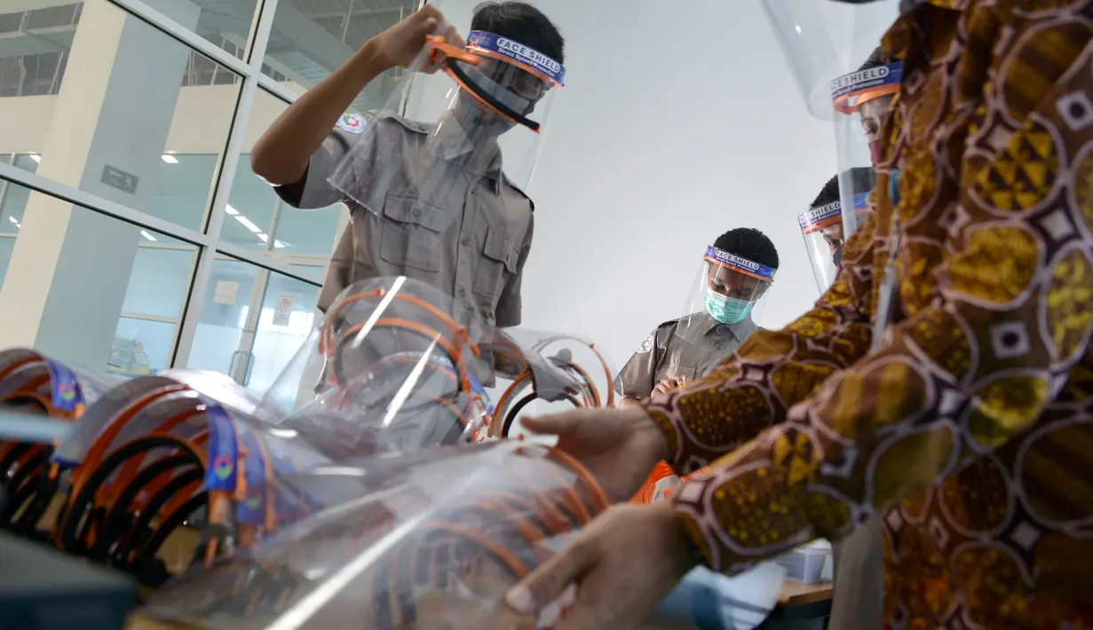 Siswa Sekolah Menengah Kejuruan memproduksi alat pelindung wajah (face shield) di Banda Aceh, Aceh, Jumat (12/6/2020). Selain memproduksi alat pelindung wajah, mereka juga membuat hand sanitizer yang akan disumbangkan untuk tenaga medis penanganan COVID-19. (CHAIDEER MAHYUDDIN/AFP)