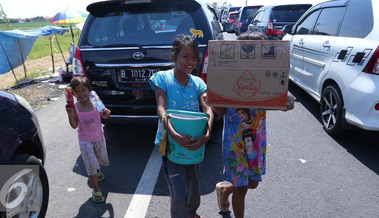 Sejumlah anak berjualan di pintu tol keluar Brebes Timur, Jawa Tengah, (3/7).Mudik lebaran dan libur sekolah di manfaatkan oleh anak-anak yang tinggal di kawasan tersebut untuk berjualan minuman dan makanan. (Liputan6.com/Angga Yuniar)