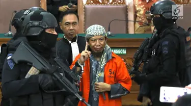 Terdakwa kasus bom Thamrin, Aman Abdurrahman dengan kawalan ketat polisi bersenjata hadir di ruang sidang Pengadilan Negeri Jakarta Selatan, Jumat (25/5). Agenda sidang adalah pembacaan nota pembelaan Aman Abdurrahman. (Liputan6.com/Immanuel Antonius)