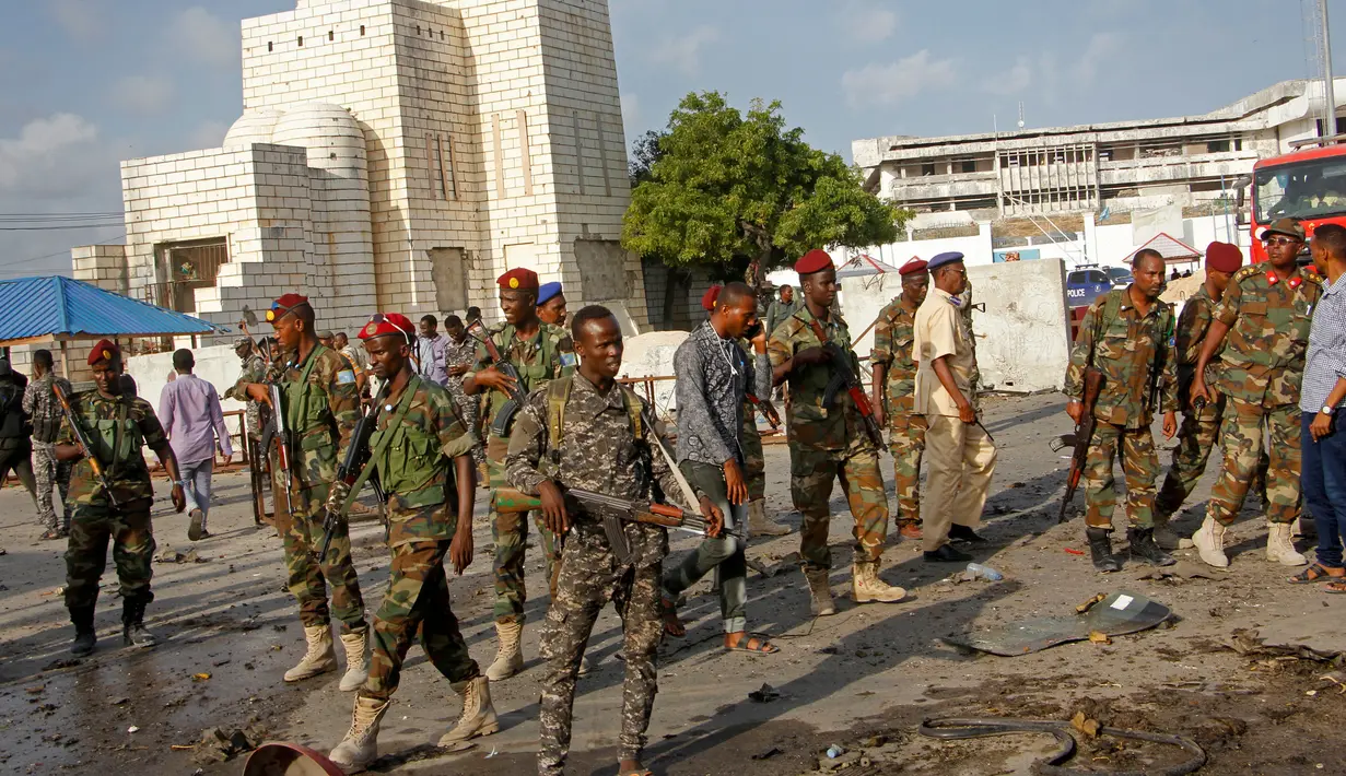 Sejumlah tentara mengamankan lokasi ledakan bom mobil yang terjadi dekat pos pemeriksaan parlemen dan Kementerian Dalam Negeri di Ibu Kota Somalia, Mogadishu, Minggu (25/3). Mobil meledak sebelum pasukan keamanan memeriksanya. (AP/Farah Abdi Warsameh)