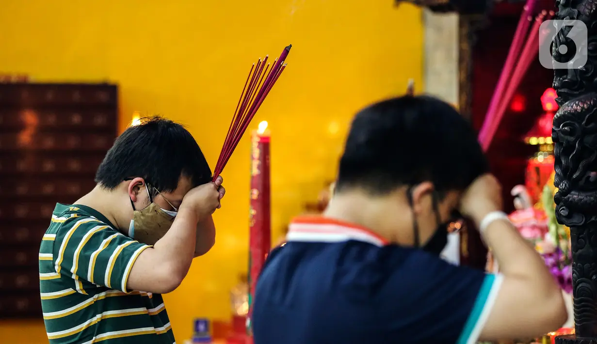 Warga Tionghoa beribadah malam perayaan Tahun Baru Imlek 2573 di Vihara Amurva Bhumi, Jakarta, Senin (31/1/2022). Pengurus Vihara mengatakan Ibadah Imlek pada tahun ini dilakukan pembatasan sampai pukul 20.00 akibat pemberlakuan PPKM level tiga di Jakarta. (Liputan6.com/Johan Tallo)