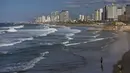 Seorang perempuan berjalan di tepi pantai Laut Mediterania Tel Aviv, Israel, Kamis (2/12/2021). Economist Intelligence Unit (EIU) pada 1 Desember mengumumkan Tel Aviv telah menggeser posisi Paris sebagai kota termahal di dunia untuk ditinggali. (AP Photo/Oded Balilty)