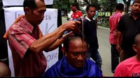 Para aktivis mencukur rambut sampai gundul sebagai bentuk syukur setelah KPK menangkap dan menahan Bupati Batubara, Sumatera Utara, OK Arya Zulkarnaen. (Liputan6.com/Reza Efendi)
