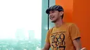 Norman Kamarau tampil santai dengan mengenakan kaos orange, celana jeans dan topi, Jakarta. Foto diambil pada Jumat (21/11/2014). (Liputan6.com/Panji Diksana)