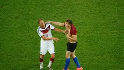 Benedikt Hoewedes mencoba mengelak dari serangan fans nakal tersebut, Brasil, Senin (14/07/2014) (AFP PHOTO/FABRIZIO BENSCH)