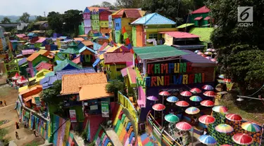 Suasana kampung warna-warni dari atas jembatan di Kelurahan Kesatrian, Kota Malang, Minggu (5/11). Ratusan rumah yang berdiri di bantaran Sungai Brantas di cat gambar warna-warni. (Liputan6.com/Fery Pradolo)