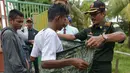 Polisi Syariat Islam memakaikan kain sarung pada warga bercelana pendek saat razia penertiban hukum syariat islam di Banda Aceh, Aceh, Selasa (19/9). Razia digelar sebagai implementasi Qanun Aceh No 11 Tahun 2002. (CHAIDEER MAHYUDDIN/AFP)