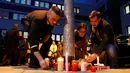 Karyawan maskapai Germanwings menyalakan lilin di kantor pusat di Bandara Cologne Bonn, Jerman, Selasa (24/3/2015). Pesawat yang membawa 150 penumpang itu jatuh dalam perjalanan dari Barcelona, Spanyol menuju Dusseldorf, Jerman. (REUTERS/Wolfgang Rattay)