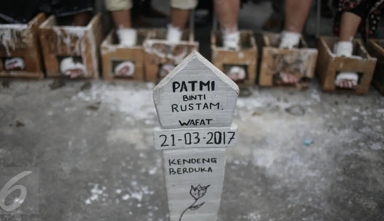 Nisan untuk Patmi (48), peserta aksi semen kaki yang meninggal, di depan Istana Merdeka, Jakarta, Rabu (22/3). Delapan aktivis dari sejumlah LSM menggelar aksi semen kaki untuk menghormati dan melanjutkan perjuangan Ibu Patmi. (Liputan6.com/Faizal Fanani)