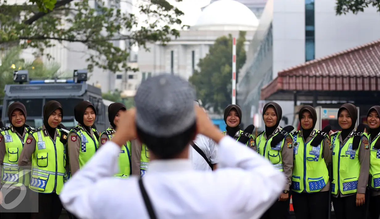 Aksi Damai 4 November diwarnai dengan aksi foto bersama antara pendemo dengan polwan berhijab, Jakarta, Jumat (4/11).  Polwan cantik yang berjaga saat demo ini laris dan memukau para pendemo untuk berfoto bersama. (Liputan6.com/Johan Tallo)