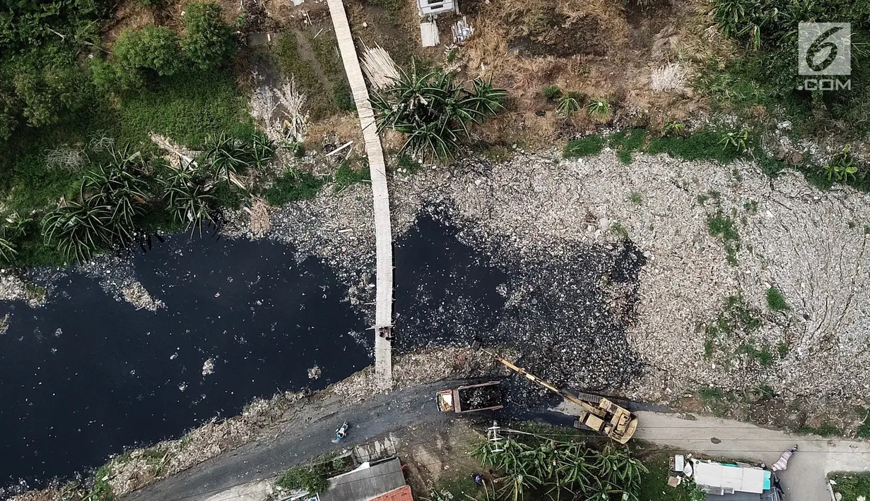 Pantauan dari udara, alat berat mengeruk sampah yang menutupi Kali Pisang Batu, Tarumajaya, Bekasi, Rabu (9/1). Sampah rumah tangga yang diduga dari aliran kali di wilayah Kota Bekasi  dikeluhkan warga karena bau tidak sedap. (Liputan6.com/Fery Pradolo)